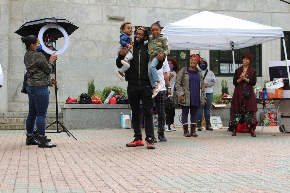 Omari Maynard, whose partner Shomany Gibson died from pregnancy-associated causes in 2019, holds his two children at the May 8th Rally.